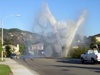 Royalty Free Photo of a Water Main Exploding In A Neighborhood