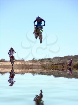 Royalty Free Photo of Motorcycles Jumping Over Water