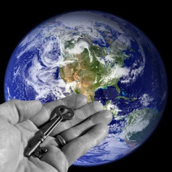 Royalty Free Photo of a Person Holding a Skeleton Key by Earth