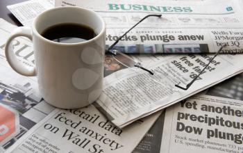Royalty Free Photo of a Cup of Coffee and Newspapers