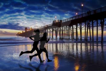 Two friends splash down the coast in the last light near the Oceanside Pier. Oceanside is 40 miles North of San Diego, California.