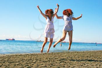 Royalty Free Photo of Two Women Jumping on the Beach