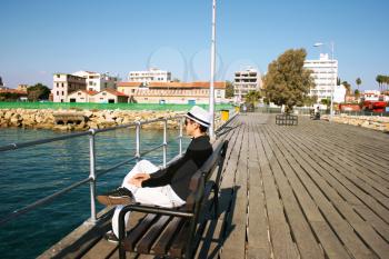 Royalty Free Photo of a Man Sitting on a Pier