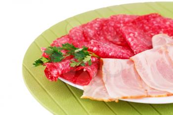 Salami and bacon on plate isolated on white background.