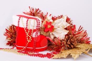 Christmas decoration with Santa's red boot, garland, beads isolated on gray background.