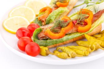 Smoked fish with fresh vegetables on plate.