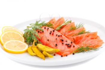 Salmon fillet with lemon, dill, pepper on plate isolated on white background.