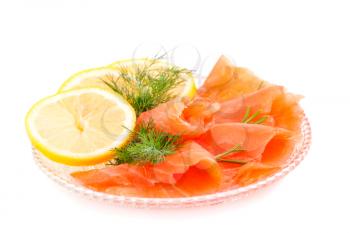 Salmon fillet with lemon and dill on plate isolated on white background.