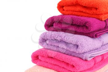 Colorful folded towels stack on white background.