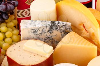 Various type of cheese and grapes closeup picture.