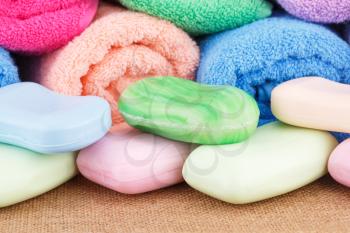 Colorful rolled towels with soaps closeup picture.