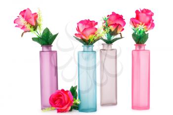 Pink fabric roses in colorful vases isolated on white background.