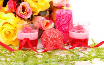 Colorful flowers and candles on white background.