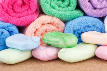 Colorful rolled towels with soaps closeup picture.
