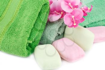 Folded towels, soaps and flowers closeup picture.