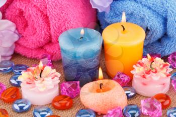 Spa set with towels, candles and stones on canvas background.