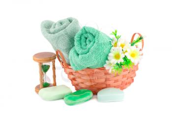 Spa set with towels, soaps, sandglass  and flowers isolated on white background.