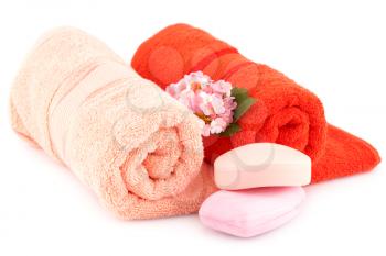 Colorful rolled towels with flowers and soaps isolated on white background.