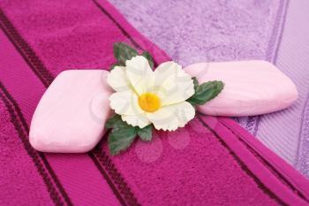 Colorful towels, flower and soaps closeup picture.