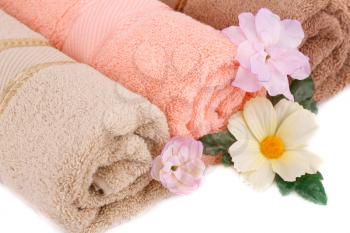 Rolled towels and flowers closeup picture.