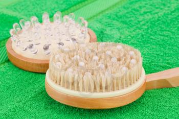 Wooden massagers on green towel, closeup picture.