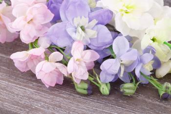 Colorful fabric flowers on wooden background, closeup picture.