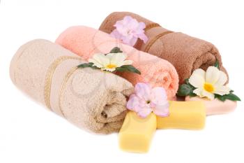 Rolled towels, soaps and flowers isolated on white background.