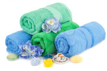 Spa set with towels, candles and flowers isolated on white background.