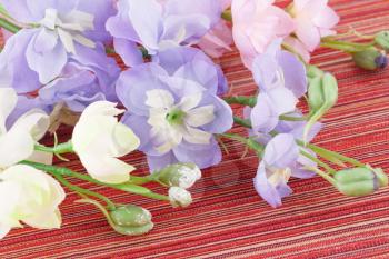 Colorful fabric flowers on cloth background, closeup picture.