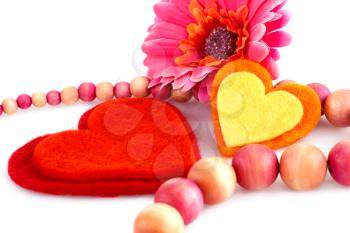 Colorful hearts, daisy flower and wooden necklace on white background.