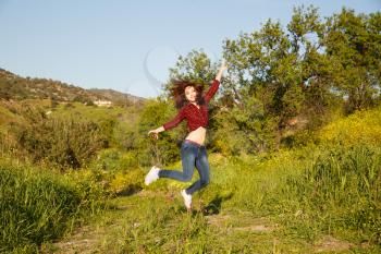 Young pretty woman jumping in garden.