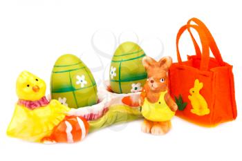 Easter decoration with colorful eggs in ceramic setting, bunny and bag isolated on white background.