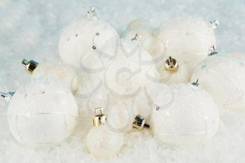 Christmas balls on the artificial snow background.