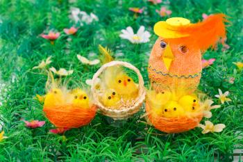 Easter setting with chickens and egg on grass background.