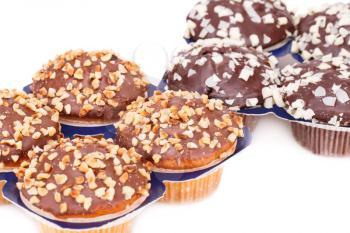 Muffins with chocolate and nuts on white background.