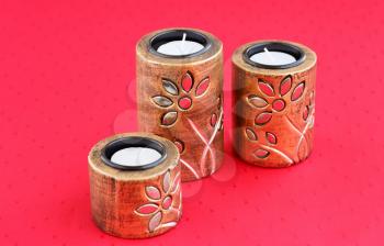 Three brown ancient style candle nests on cloth background.