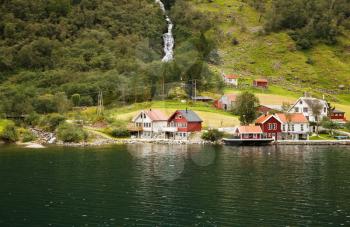 Landscape with Naeroyfjord, waterfall, mountains and traditional village houses in Norway.