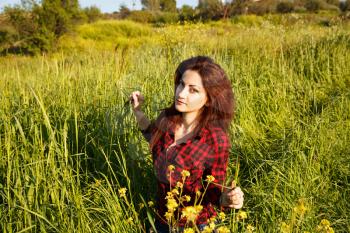 Young pretty woman in green field.