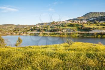 Cyprus landscape with mountains, lake and village.