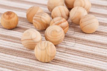 Wooden balls on beige fabric background.