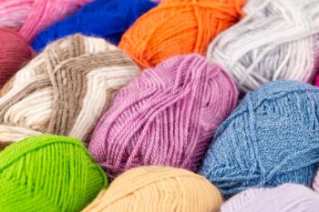 The stack of colorful knitting yarn clews close up picture.