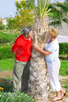 Elderly couple playfully looks at each other in tropical country.