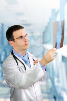 Friendly medical doctor stand with a x-ray image and medical pad in a Hospital.