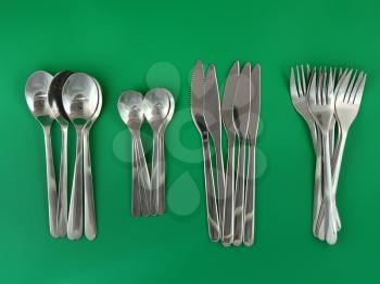 Table serving-knife,plate,fork and   on  green background.