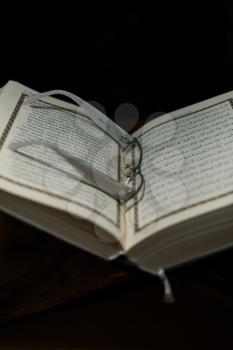 pages of holy koran and glasses