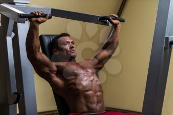 male bodybuilder doing heavy weight exercise for upper chest