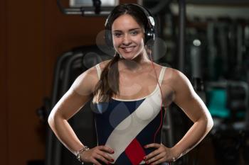 Cute Girl With Headphones Relaxing In The Gym