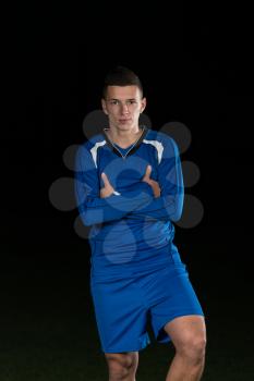 Portrait Of A Soccer Player And Ball On Football Stadium Field Isolated On Black Background