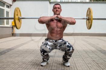 Bodybuilder Doing Front Squats With Barbells