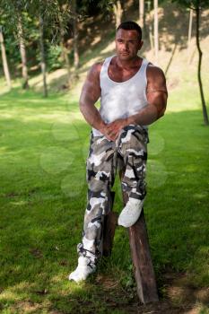 Bodybuilder Posing In A Field